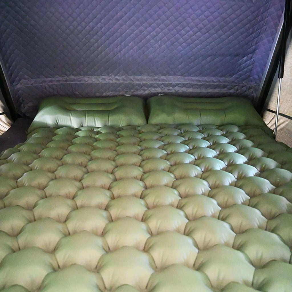Matelas gonflable confortable pour tente de toit, conçu pour le camping, avec des coussins intégrés et un design spacieux pouvant accueillir jusqu'à deux personnes.
