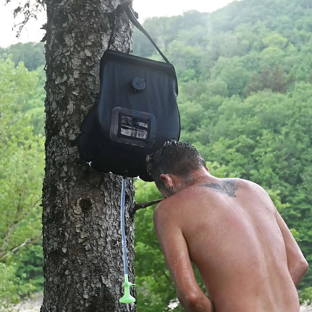 Homme utilisant un sac de douche solaire de 20L en extérieur, idéal pour le camping, la randonnée et les aventures écologiques.